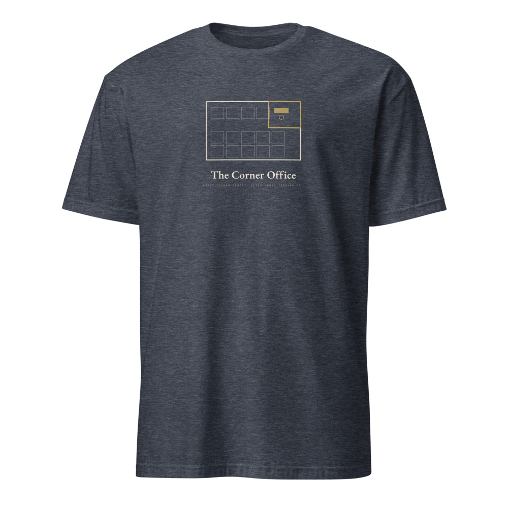 Heather navy t-shirt printed with a cream architectural floor plan: rows of identical cubicles and one gold corner office